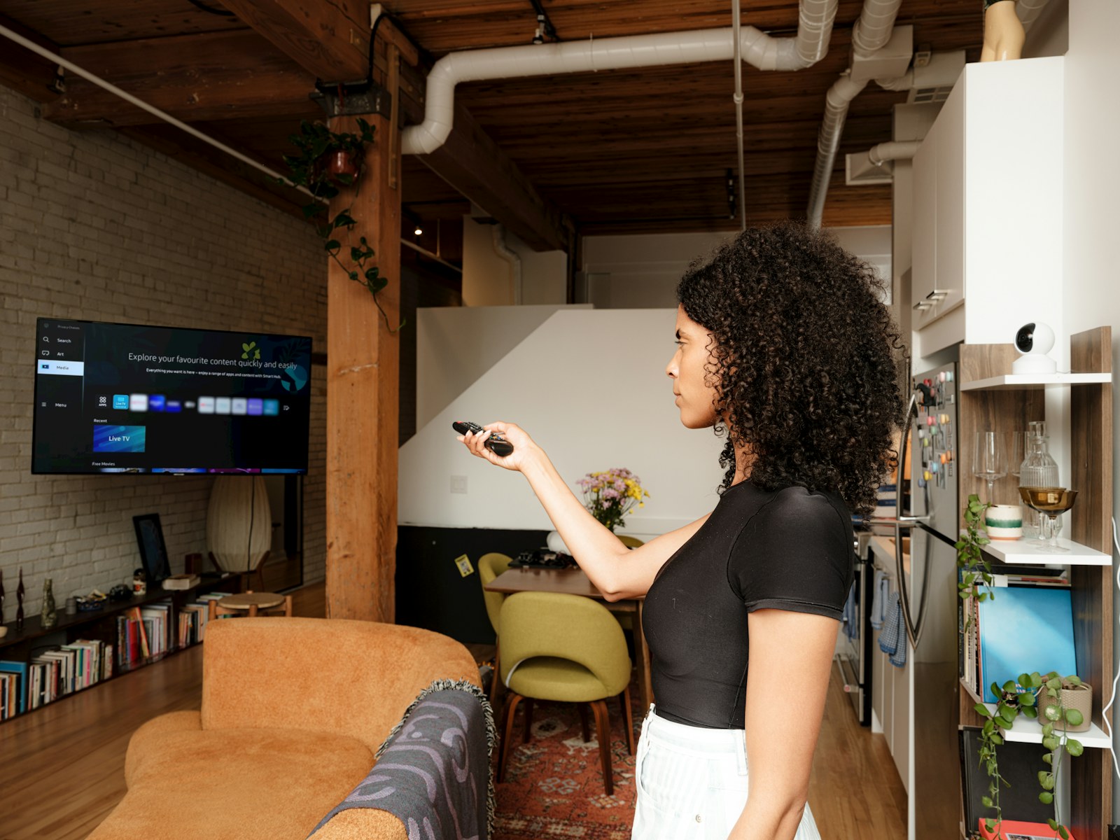 Pessoa a testar uma Smart TV com comando antes de escolher IPTV em Portugal